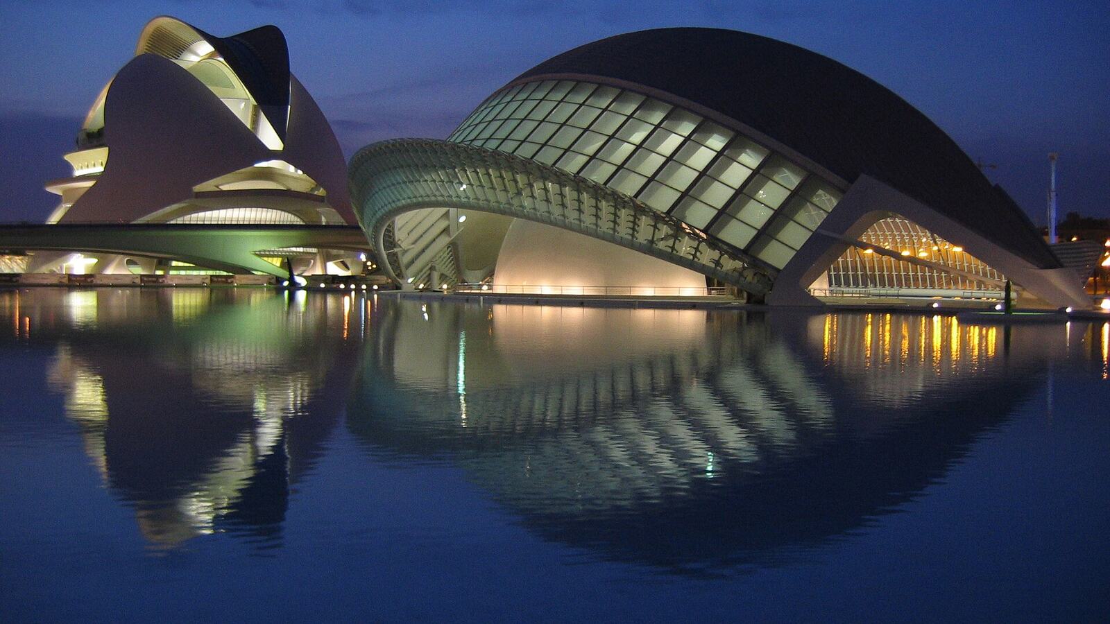 De Stad van Kunsten en Wetenschappen in Valencia 's avonds verlicht en weerspiegeld in het water