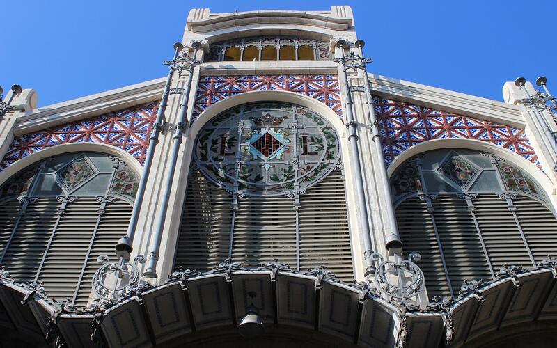 De modernistische gevel van de Mercado Central met glas-in-lood en tegels