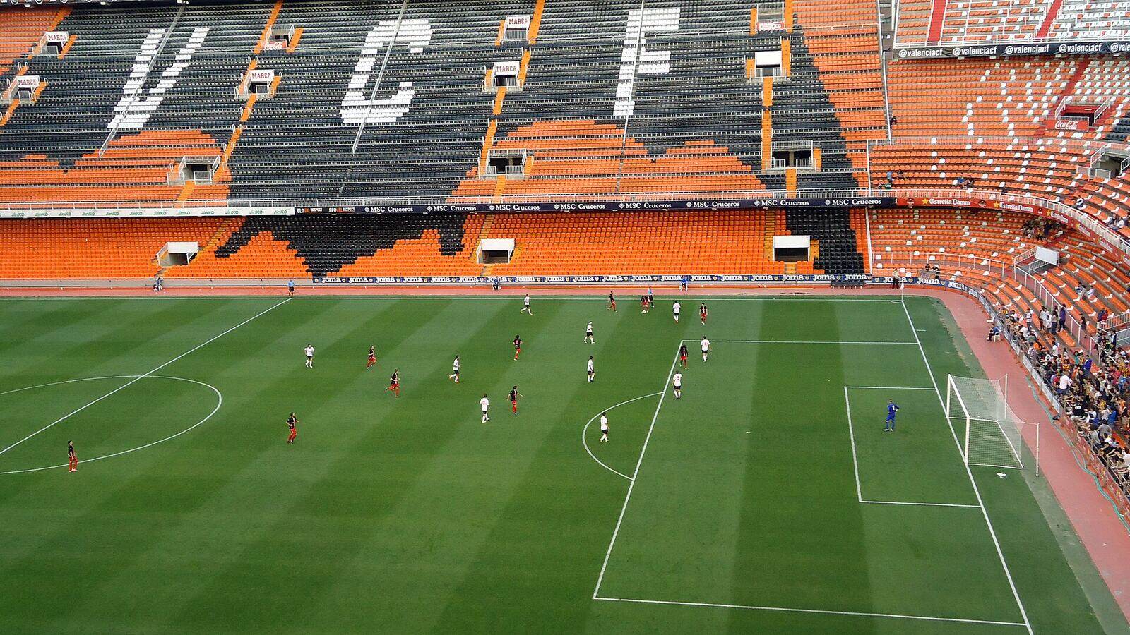 Het veld en de steile tribunes van het voetbalstadion Mestalla in Valencia