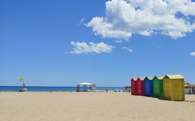Gekleurde strandhuisjes en zand op het strand van La Patacona bij Valencia