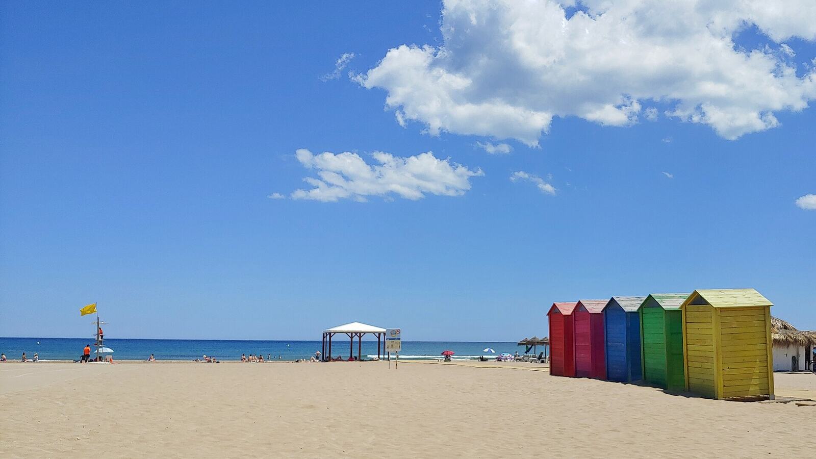 Gekleurde strandhuisjes en zand op het strand van La Patacona bij Valencia